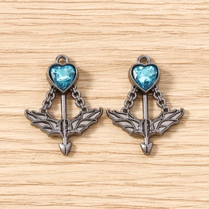 Detailed view of cupid arrow heart pendants with blue crystals and gun black finish