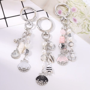 Ocean themed pearl keychain set with anchor shell and tropical fish charms on a bag pendant