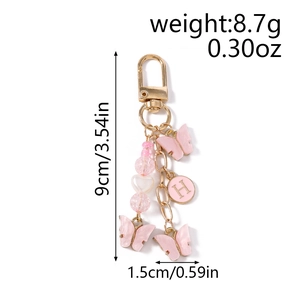 Porte-clés papillon rose avec bracelet perlé et breloque lettre H sur fond blanc épuré
