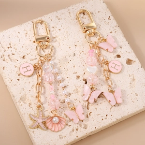 Porte-clés perlé avec papillon rose et étoile de mer et breloque lettre H dorée