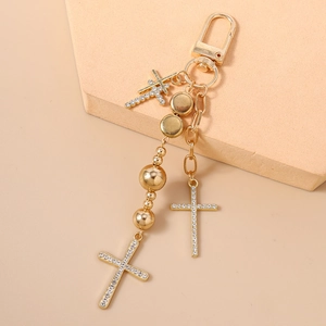 Macro shot of layered gold beaded keychain with rhinestone cross charms and beads