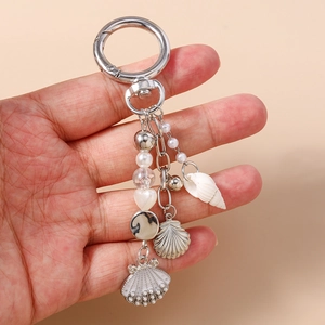 Detailed close-up of pearl bead keychain featuring conch, shell, and anchor charms