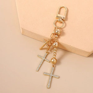 Detail of gold beaded keychain with sparkling rhinestone cross pendants and lobster clasp