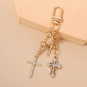 Detailed macro of gold-plated key chain with three diamond-encrusted cross pendants