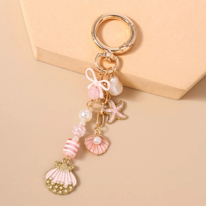 Detailed view of ocean theme keychain with gold starfish, pink shells and white pearls