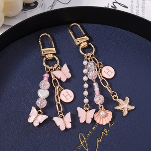 Porte-clés papillon rose avec perles, étoile de mer et cœurs pour décoration de sac