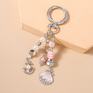 Detailed close-up of nautical charms with sea shell and anchor on the pearl keychain