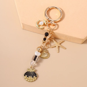 Detail of nautical keychain with gold starfish, anchor charms and striped beads