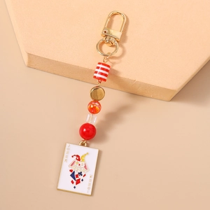 Detail of beaded keychain featuring a colorful Joker illustration pendant with gold hardware