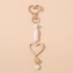 Detail of beaded heart keychain featuring baroque pearl and gold openwork heart pendant