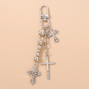 Macro detail of silver tone keychain with sparkling rhinestone cross and metal beads