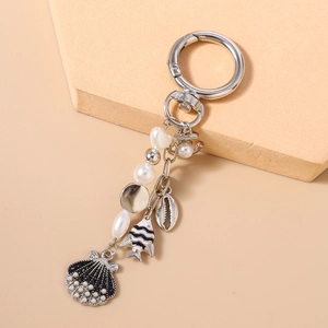 Detail of nautical keychain with pearl beads, striped fish, and black seashell charm