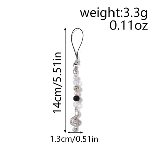 Detailed view of musical note phone charm with sparkling rhinestones and white pearls
