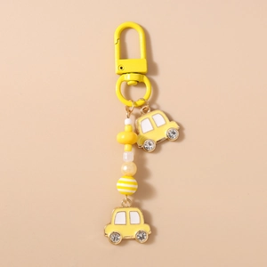 Detail eines gelben Auto-Schlüsselanhängers mit Perlen, Strass und goldenem Verschluss
