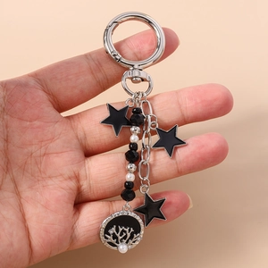 Vue détaillée du porte-clés avec pendentifs étoiles noires et disque corail ajouré