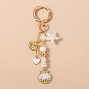 Detail of nautical keychain with enamel shells, starfish, and pearls on gold clasp