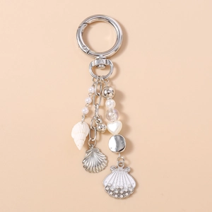 Detail of silver anchor and shell charms with white pearls on a nautical keychain