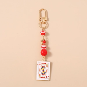Detail of beaded keychain with gold hook, red beads, and bunny poker card pendant