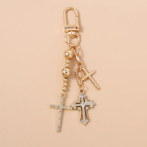 Detail of beaded keychain with rhinestone cross pendants and lobster clasp in gold finish