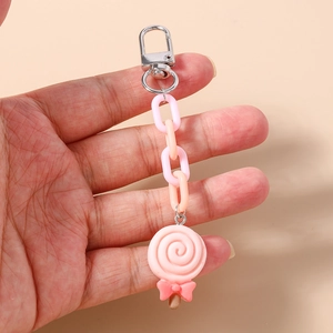 Detailed close-up of a pink lollipop keychain with bow and colored plastic links