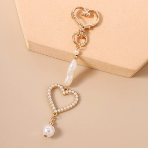 Detail of beaded heart keychain with baroque pearl accents and a golden heart frame