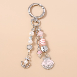 Detail of nautical keychain with pink jellyfish, anchor, and shell pendants with pearls