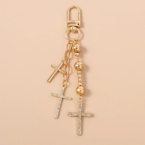 Detailed view of golden beaded keychain featuring multiple rhinestone-encrusted crosses