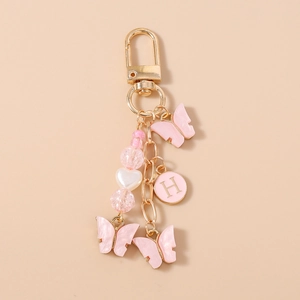 Porte-clés papillon rose avec pendentif lettre H dorée et perles en cœur