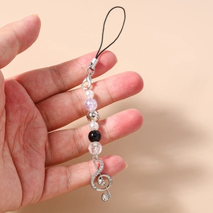 Detail of beaded phone charm featuring a silver treble clef pendant and assorted pearls