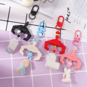 Plush animal claw crane machine keychains in black, white, red, and pink colors