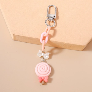Detail view of pink lollipop keychain with white resin bow and silver carabiner clip