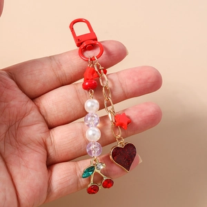 Detailed close-up of cherry charm keychain with glitter heart and red star pendant