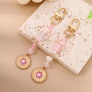 Porte-clés en perles roses avec nœud papillon, breloque soleil dorée et strass brillants