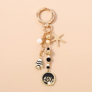 Détails du porte-clés thème océan avec étoile de mer dorée et pendentif corail chic
