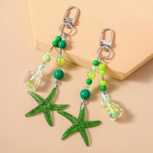 Porte-clés étoile de mer verte avec perles rayées et breloque bouteille miniature