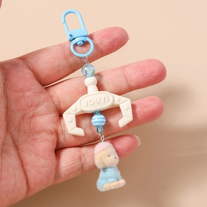 Detail of plush puppy keychain with blue plastic hook and colorful beads held in hand