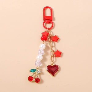 Detail of red cherry and glittery heart pendants on a beaded star keychain charm