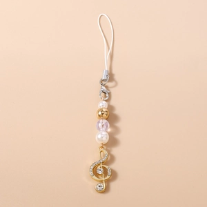 Detail of music theme phone charm with gold treble clef pendant and white pearls