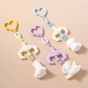 Creative plush dog keychain with claw machine hook and colorful beads on tan background