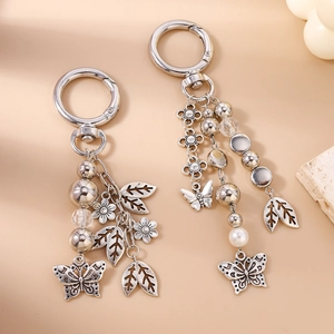 Vintage silver butterfly and leaf beaded keychain with white pearls on orange background
