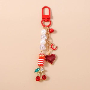 Detailed view of red beaded cherry keychain with star charm and heart pendant for bags