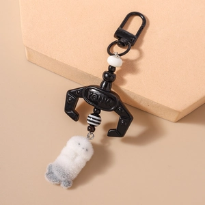 Creative black claw keychain with a white plush doll and striped bead details