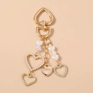 Dettaglio portachiavi a cuore dorato con strass, perle e ciondolo Love You