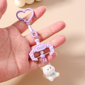 Detail of cute white plush puppy pendant with purple heart hook and bead decorations