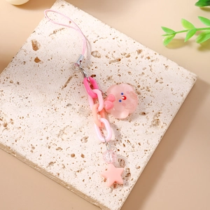 Détail d'un pendentif d'étoile rose et fleur sur une chaîne de téléphone stylée en résine
