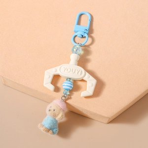 Detail of creative blue crane claw keychain with a cute plush puppy toy pendant