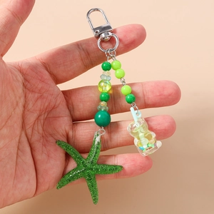 Détail de l'étoile de mer en résine verte et pendentif tasse de thé au lait avec fermoir