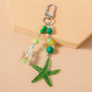 Détail de porte-clés thème marin vert avec étoile de mer et perles à rayures