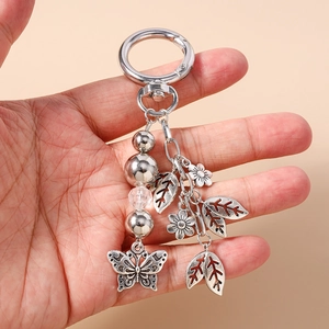 Close-up of vintage silver keychain with hollow butterfly, daisy, and leaf charms