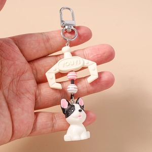 Detail of creative dog keychain featuring a white claw charm and striped beads in hand